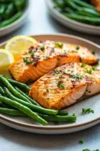 Close-up of air fryer salmon and green beans with bright natural lighting